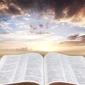 open bible with bright sky among the clouds