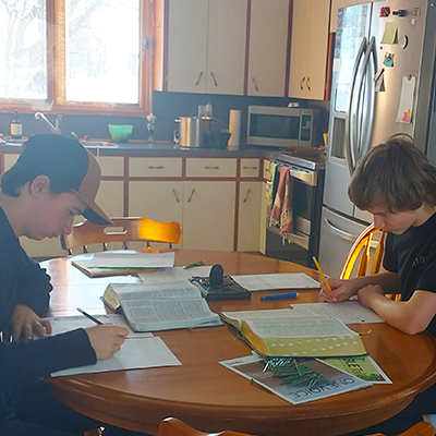 boys doing learning work at the kitchen table