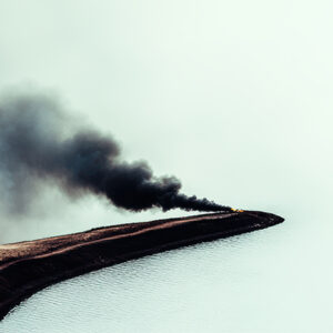 smoke in the distance surrounded by calm waters
