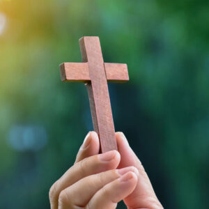 hand holding a small wooden cross